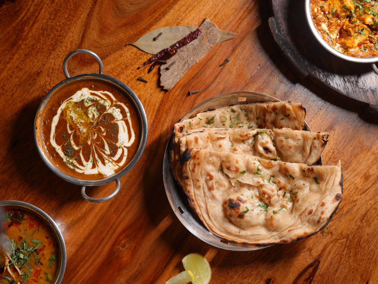 Stacked kulchas with dal makhani and a rich house curry