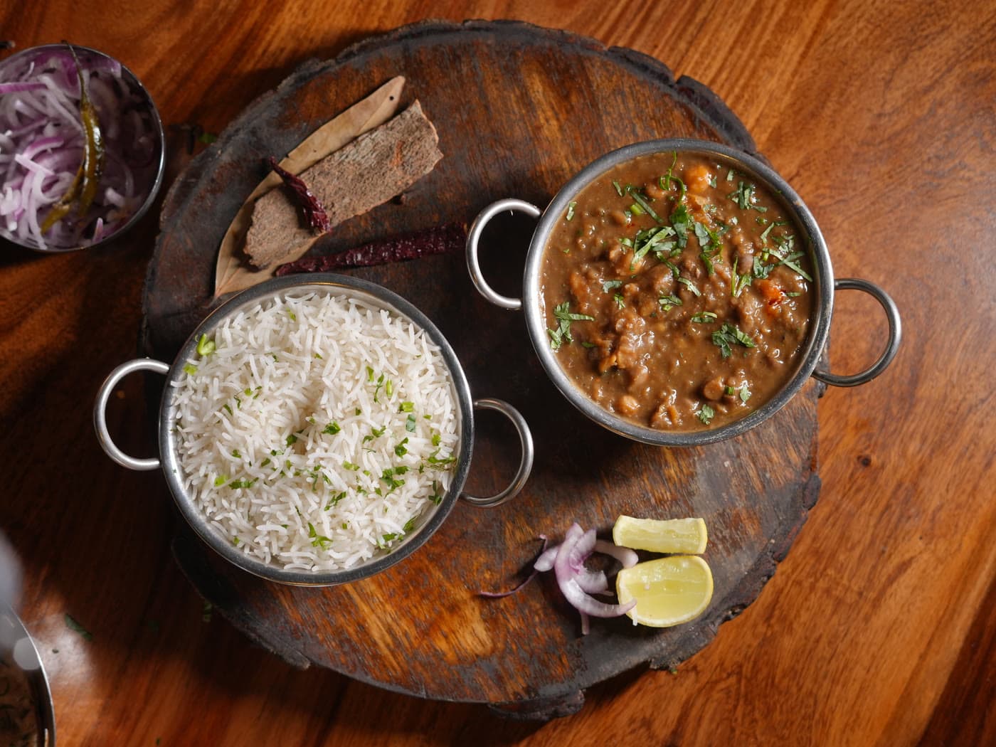 Jeera rice and slow-cooked curry served in copper